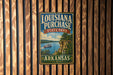 A vintage-style metal sign for Louisiana Purchase State Park in Arkansas, featuring a scenic image of a river and a steamboat.