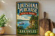 A vintage-style sign for Louisiana Purchase State Park in Arkansas, featuring a scenic illustration of a river and a steamboat.