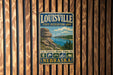 A vintage metal sign for the Louisville State Recreation Area in Nebraska, featuring a scenic landscape with a lake and mountains.