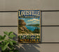 A vintage-style metal sign for the Louisville State Recreation Area in Nebraska, featuring a scenic landscape with mountains, water, and hiking trails.