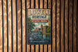 A vintage metal sign for Lowell Heritage State Park, featuring an illustration of a bridge and buildings, mounted on a wooden wall.