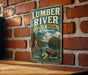 A vintage-style metal sign for Lumber River State Park in North Carolina, featuring a scenic illustration of a canoe on a river surrounded by lush greenery.