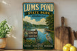 A vintage-style sign for Lums Pond State Park in Delaware, featuring a scenic image of the pond surrounded by nature, recreation, and memories.