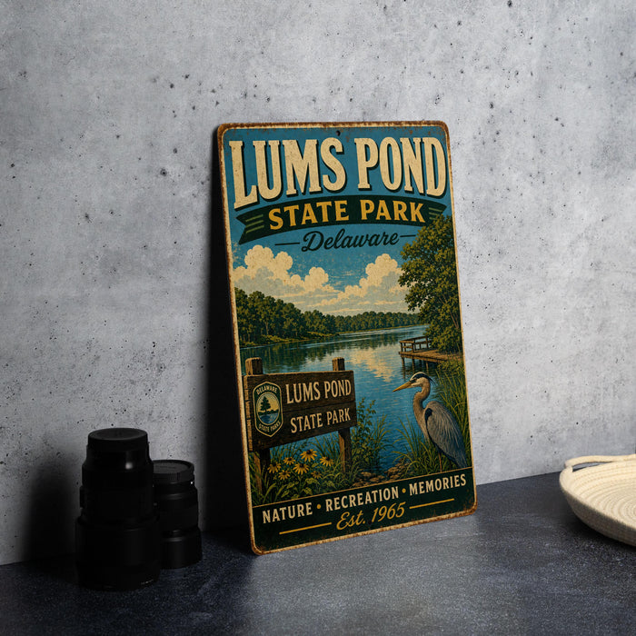 A vintage-style sign for Lums Pond State Park in Delaware, featuring a scenic illustration of the pond surrounded by nature and wildlife.