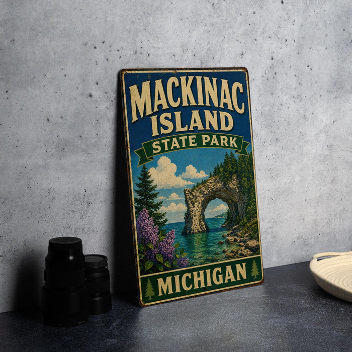 A vintage-style metal sign for Mackinac Island State Park in Michigan, featuring a scenic landscape with a bridge, trees, and water.