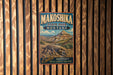 A vintage metal sign for Makoshika State Park in Montana, featuring a scenic illustration of the park's natural landscape.