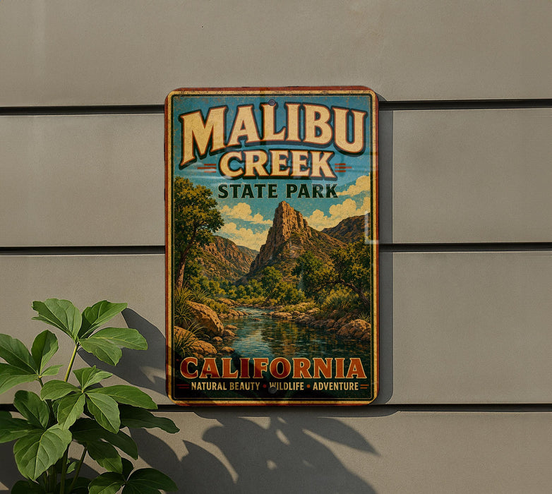 A vintage metal sign for Malibu Creek State Park in California, featuring a scenic landscape with mountains, water, and greenery.