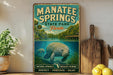 A vintage-style sign for Manatee Springs State Park in Florida, featuring an illustration of a manatee swimming in the water.