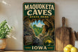 a vintage-style sign for the Maquoketa Caves State Park in Iowa, with a scenic image of the cave system and a wooden sign that reads "Explore nature's hidden wonders".