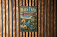 A vintage metal sign for Mark Twain State Park in Missouri, featuring a scenic illustration of a river and mountains.