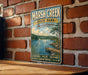 A vintage metal sign for Marsh Creek State Park in Pennsylvania, featuring a scenic illustration of a lake, dock, and surrounding forest.