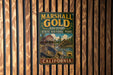 A vintage-style metal sign for Marshall Gold Discovery State Historic Park in California, featuring an illustration of a gold pan and a building.