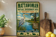A vintage-style metal sign for the Mattawoman Natural Environment Area in Maryland, featuring an illustration of a heron and a scenic landscape.