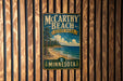 A vintage-style metal sign for McCarthy Beach State Park in Minnesota, featuring a scenic landscape with pine trees, a beach, and a lake.