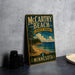 A vintage-style metal sign for McCarthy Beach State Park in Minnesota, featuring a scenic landscape with a beach, pine trees, and a lake.