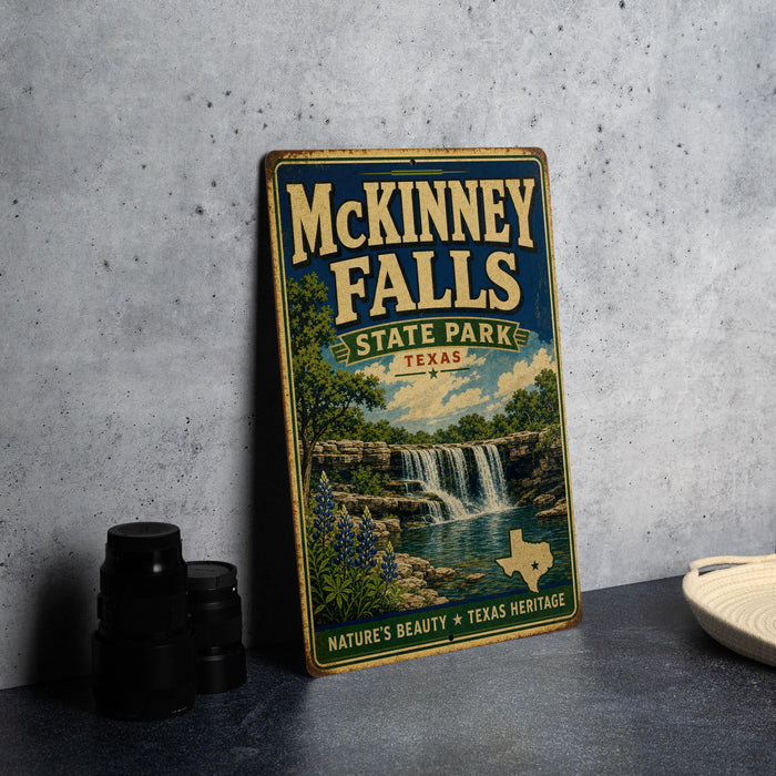 A vintage-style metal sign for McKinney Falls State Park in Texas, featuring a scenic illustration of the waterfall surrounded by nature.