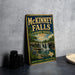 A vintage-style metal sign for McKinney Falls State Park in Texas, featuring a scenic illustration of the waterfall surrounded by nature.
