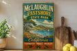 A vintage-style sign for McLaughlin Eastshore State Park, featuring a scenic landscape with a body of water, mountains, and a sailboat.