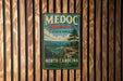 A vintage metal sign for Medoc Mountain State Park in North Carolina, featuring a scenic mountain landscape with pine trees and a cliff.