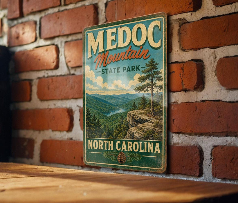 A vintage-style metal sign for Medoc Mountain State Park in North Carolina, featuring a scenic mountain landscape with pine trees and a river.