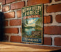 A vintage-style metal sign for Meeman-Shelby Forest State Park in Tennessee, featuring a scenic landscape with a lake and trees.