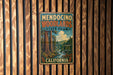 A vintage metal sign for Mendocino Woodlands State Park in California, featuring a scenic image of the park's natural surroundings.