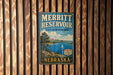 A vintage metal sign for the Merritt Reservoir State Recreation Area in Nebraska, featuring a scenic landscape with a lake, mountains, and a sailboat.