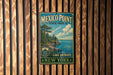 A vintage metal sign for Mexico Point State Park, featuring a scenic landscape with a lake and trees, mounted on a wooden wall.