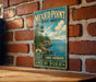 A vintage-style metal sign for Mexico Point State Park, featuring a scenic landscape with a lake and mountains in the background.