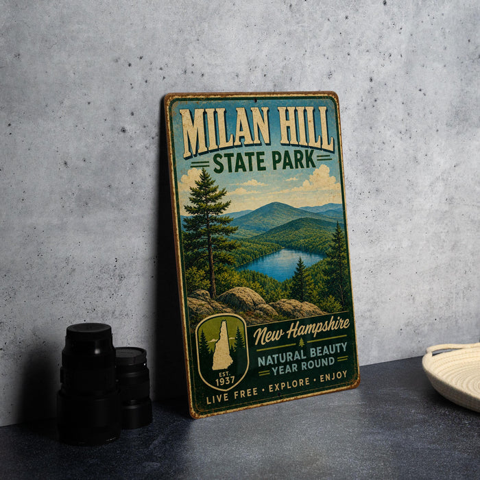 A vintage-style metal sign for Milan Hill State Park, featuring a scenic landscape with mountains, pine trees, and a lake.