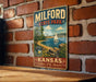 A vintage-style metal sign for Milford State Park in Kansas, featuring a scenic illustration of a lake, mountains, and a sailboat.