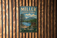 A vintage metal sign for Miller State Park, featuring a scenic landscape with a lake, mountains, and pine trees.