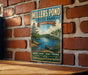 A vintage-style metal sign for Millers Pond State Park in Connecticut, featuring a scenic illustration of a lake, canoe, and surrounding forest landscape.