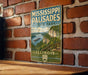 A vintage metal sign for Mississippi Palisades State Park in Illinois, featuring a scenic illustration of the park's landscape.
