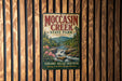 A vintage-style metal sign for Moccasin Creek State Park in Georgia, featuring a scenic illustration of the creek and mountains.