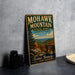 A vintage metal sign for Mohawk Mountain State Park, Connecticut, featuring a scenic mountain landscape and the text "Scenic Beauty All Four Seasons".