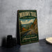 A vintage-style metal sign for the Mohawk Trail in the State Forest, featuring a scenic mountain landscape with a winding road and pine trees.