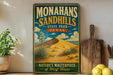 A vintage-style metal sign for Monahans Sandhills State Park in Texas, featuring an illustration of a desert landscape with a cactus and a sand dune.