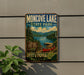 A vintage-style metal sign for Moncover Lake State Park, featuring a scenic image of a lake, mountains, and a red canoe.