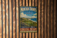 A vintage metal sign for Montauk Downs State Park in New York, featuring a scenic coastal landscape with a golf course and ocean in the background.