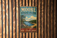 A vintage metal sign for Moore State Park in Massachusetts, featuring a scenic landscape with a lake and mountains.