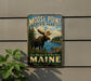 A vintage-style metal sign for Moose Point State Park, featuring a moose in a forest landscape and the text "Moose Point State Park" prominently displayed.
