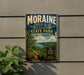 A vintage-style metal sign for Moraine Hills State Park in Illinois, featuring a scenic landscape with a trail and a sign that says "Hike Explore Discover".