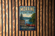 A vintage metal sign for Moraine State Park in Pennsylvania, featuring a scenic image of a lake with a boat and trees, mounted on a wooden wall.