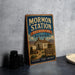 A vintage-style sign for Mormon Station, a historic park in Nevada, featuring an illustration of a wagon and a sign that reads "A Reminder of Nevada's Pioneer Heritage".