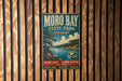 A vintage metal sign for Moro Bay State Park in Arkansas, featuring a scenic landscape with a lake and mountains.