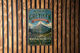A vintage metal sign for Mount Greylock State Reserve in Massachusetts, featuring a mountain landscape and the text "The Highest Peak in Massachusetts".