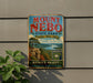 A vintage metal sign advertising Mount Neobo State Park in Arkansas, featuring a scenic landscape with a river and mountains.