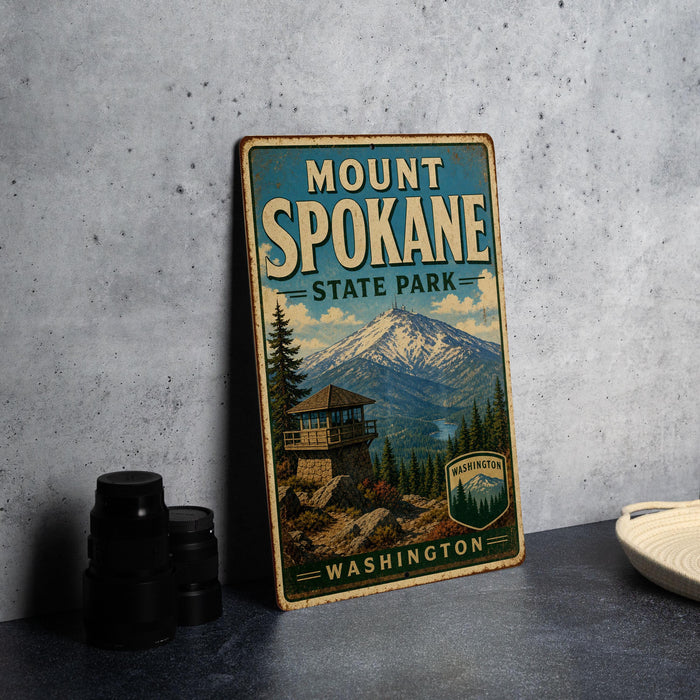 A vintage-style metal sign for Mount Spokane State Park in Washington, featuring a mountain landscape and a lookout tower.