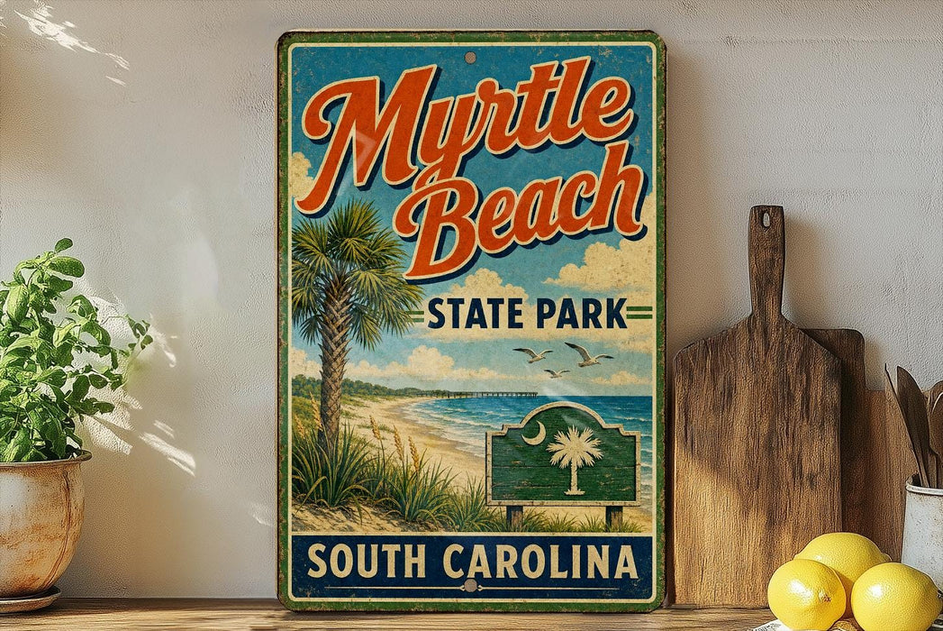 A vintage-style metal sign for Myrtle Beach State Park in South Carolina, featuring a palm tree and beach scene, is displayed on a shelf next to a wooden cutting board and some lemons.